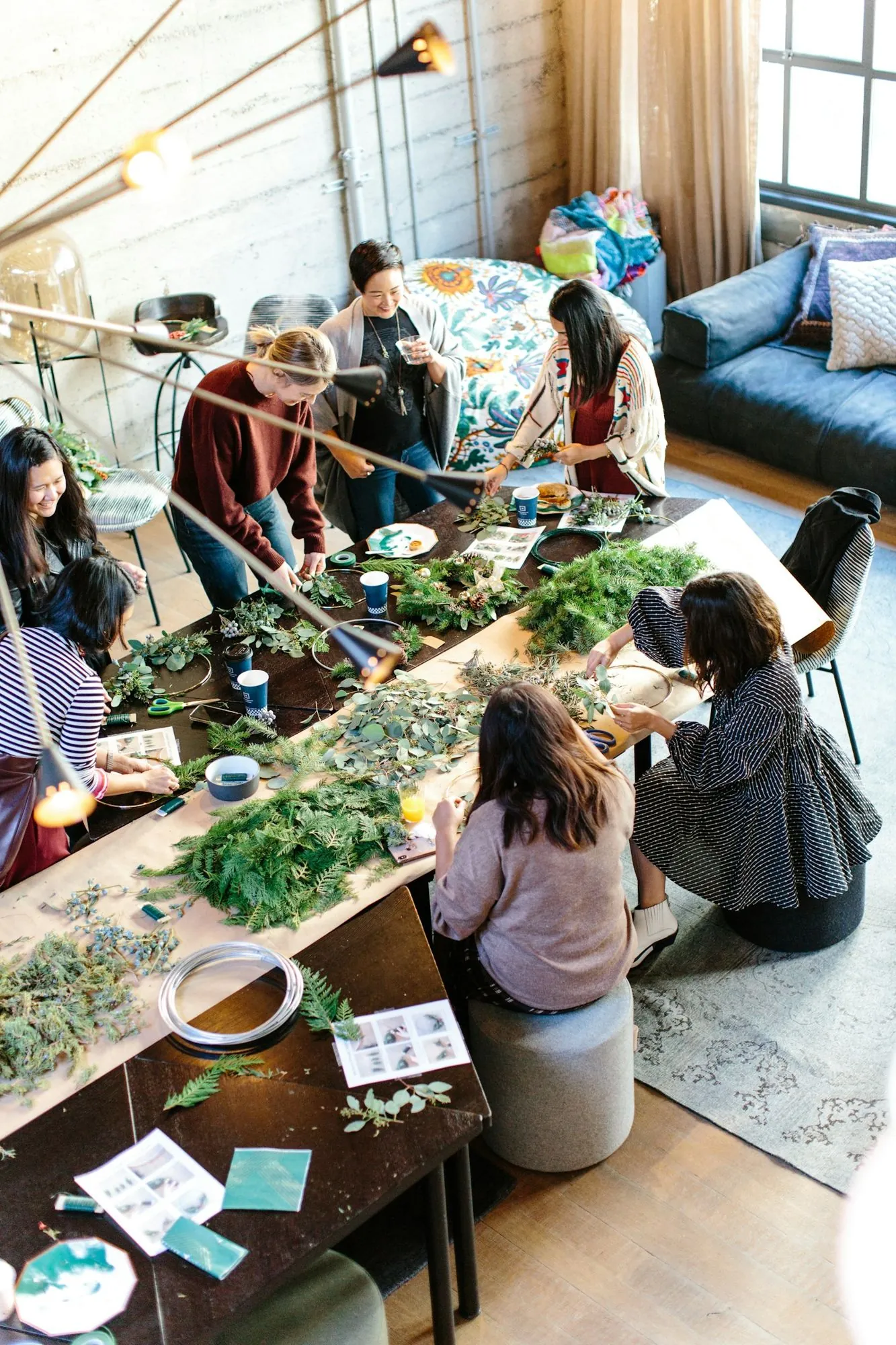 Participantes d’un atelier floral autour d’une grande table de travail