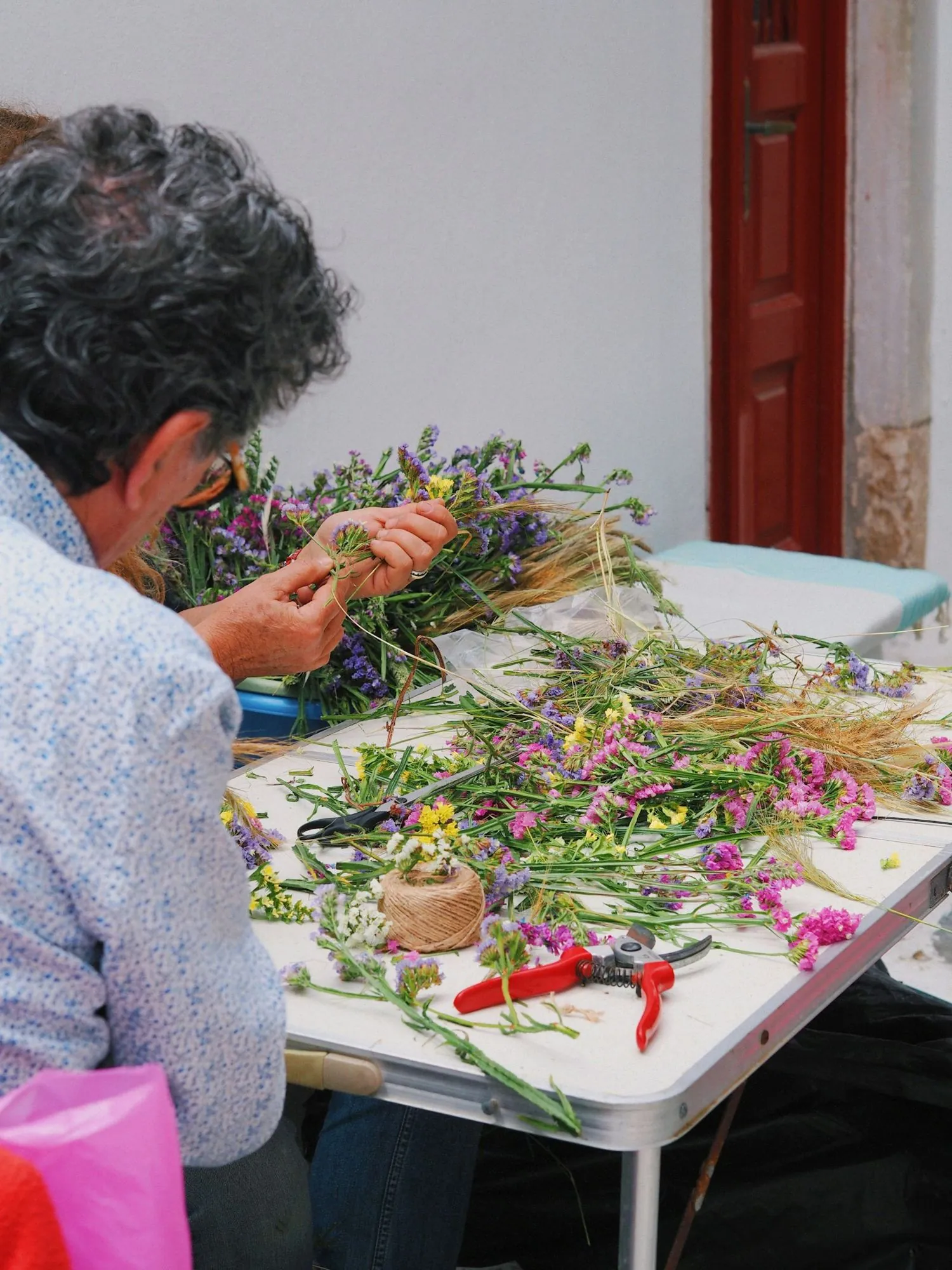 Participante composant un bouquet de fleurs des champs à l’atelier